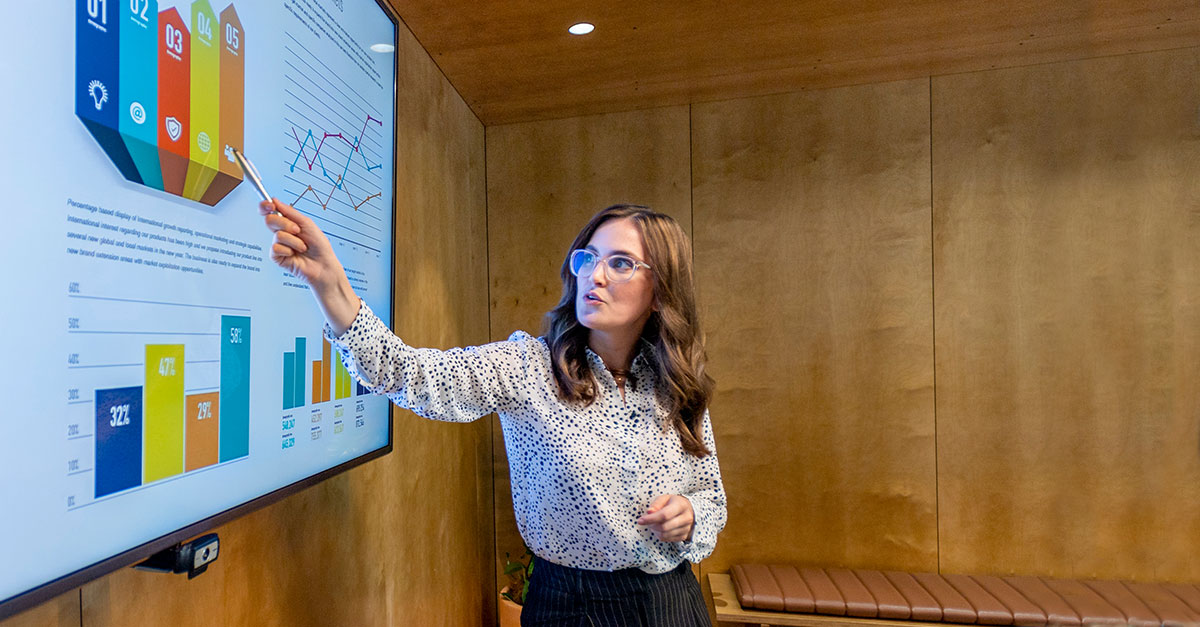 Woman standing by Ai screen presentation