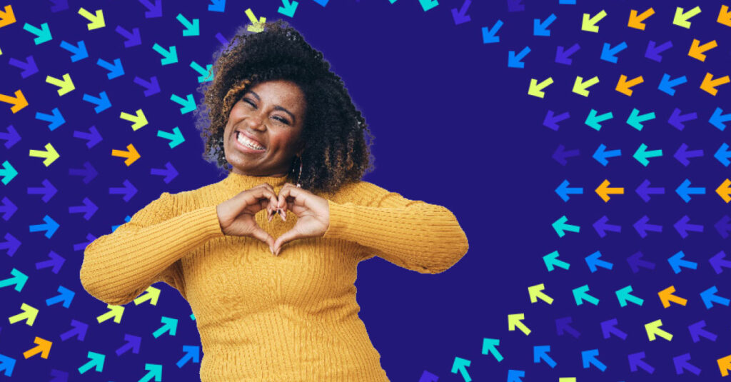 Woman on dark blue background making heart shape with hands.